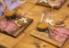 Women sitting at a table in a restaurant in Florence enjoying various Italian meats and wine.